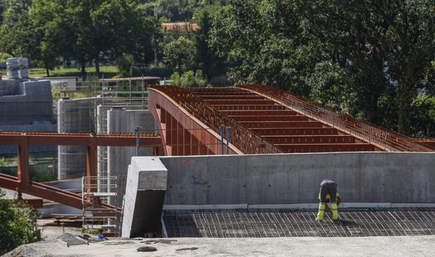 Un operario, trabaja en el nuevo puente de Golbardo, que ya tiene una estructura metálica instalada. 