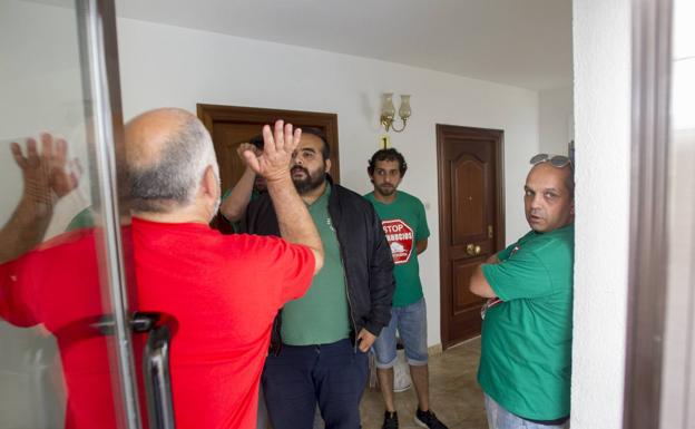 Los responsables de la plataforma Stop-Desahucios, la Guardia Civil y los representantes judiciales, conversan en el portal. 