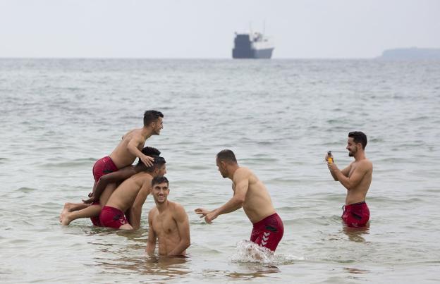 Rafael de Vicente fotografía a varios de sus compañeros en el chapuzón que se dieron los racinguistas tras el entrenamiento en la playa.