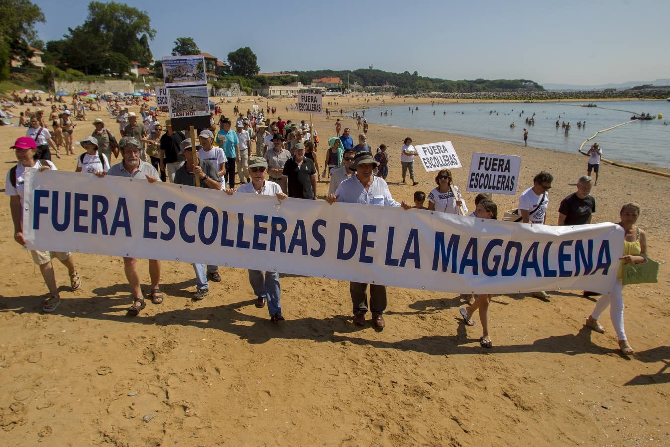 La plataforma ciudadana 'Salvar La Magdalena' ha celebrado hoy una nueva concentración para pedir la retirada de las escolleras que se están ejecutando en el arenal. El acto se ha celebrado en el Balneario de la Magdalena a las 12.30 horas y, además de la concentración en sí, ha incluido un 'pasaplayas'. Los manifestantes han aprovechado la bajamar para realizar un paseo por la orilla encabezado por un pito y tamboril con globos, pancartas y camisetas reivindicativas.