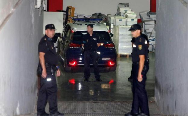 Varios agentes, junto el coche en el que han desplazado al asesino confeso. 