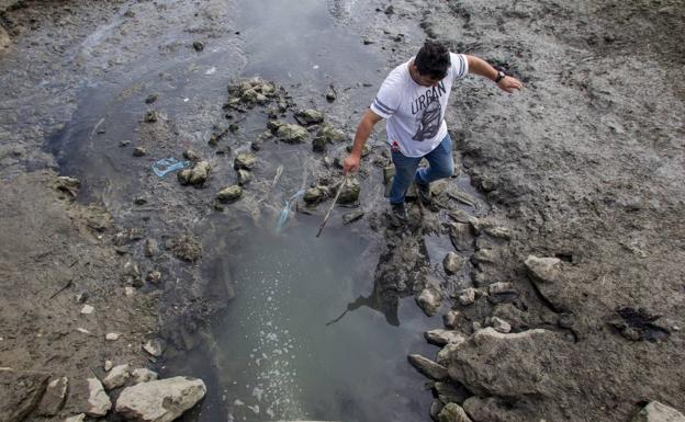 Un vecino señala los vertidos fecales que van directamente al mar en el barrio de La Rivera, en Cicero.