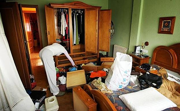 Una mujer registra su domicilio tras ser asaltado por unos ladrones.