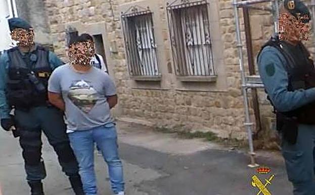 Los agentes de la Guardia Civil custodian a uno de los detenidos en la operación.