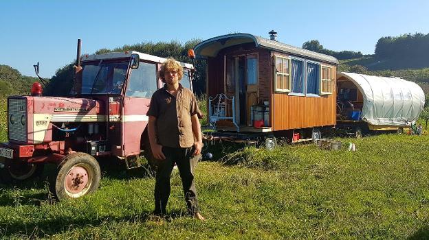 Joris Vangesselen, con el tractor y las dos caravanas con las que han llegado desde Bélgica, en la finca situada junto a la playa de Merón.