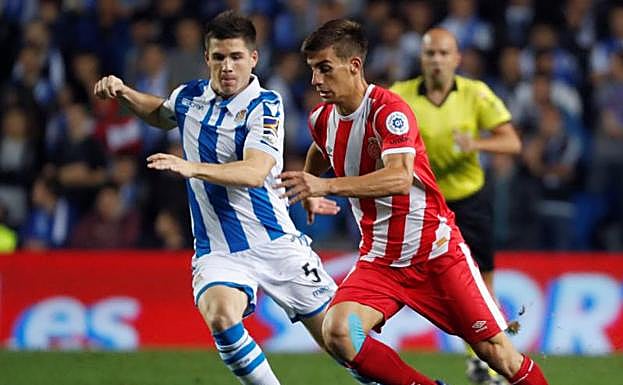 El centrocampista de la Real Sociedad Igor Zubeldia (i), pelea un balón con el centrocampista del Girona Pere Pons.