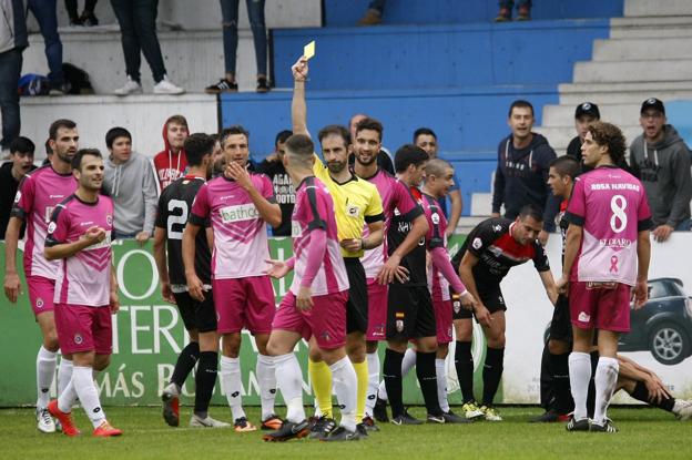 El colegiado González Esteban muestra la cartulina amarilla al gimnástico Primo por protestar su decisión de pitar penalti. 