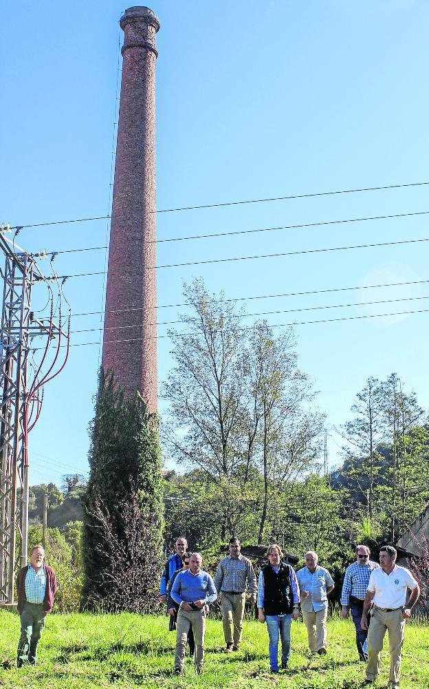 Representantes de colectivos e instituciones posan ante la chimenea de 'El Pavón', en Villapresente. 