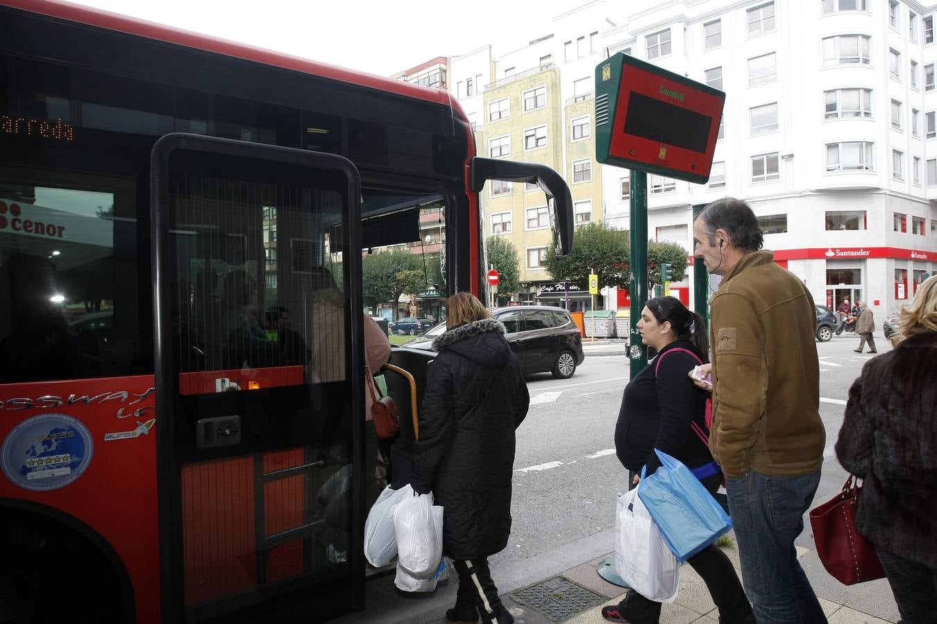 Varios viajeros suben al Torrebús en una céntrica parada de la calle José María Pereda. 