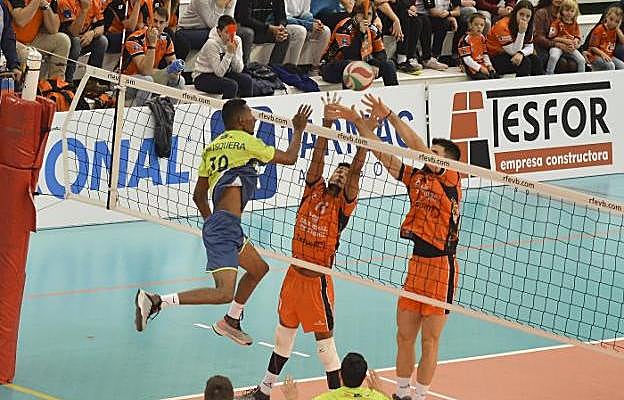 Mosquera intenta un remate ante dos jugadores del Teruel. :: club voleibol teruel