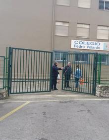 Imagen secundaria 2 - La Policía Local, atendiendo a una familiar del fallecido. Debajo, momento del levantamiento del cadáver y, después, retirada de las pelotas por parte de personal del colegio.