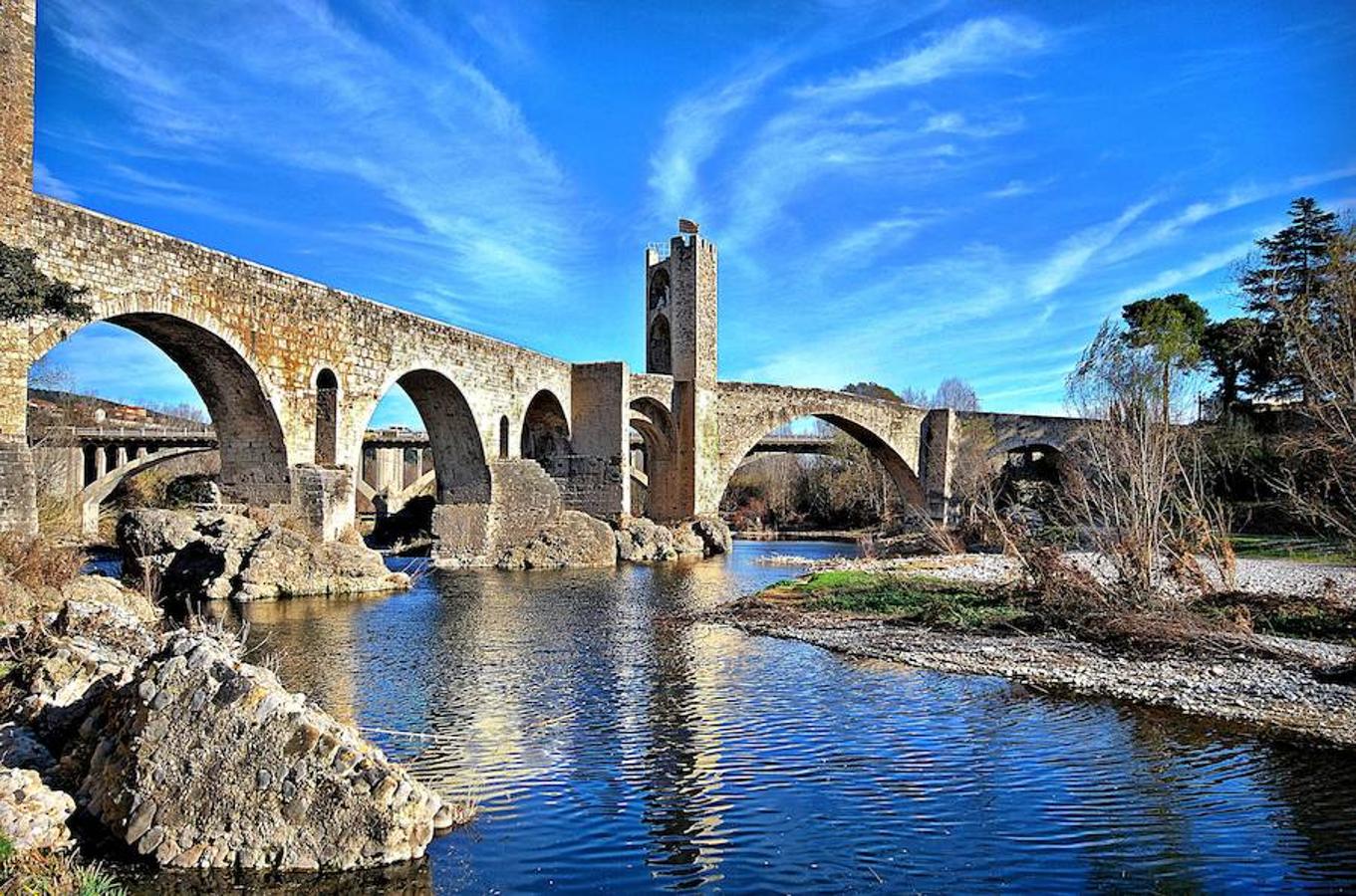 Besalú (Girona) | Una fortaleza medieval entre dos ríos, cerca de la frontera con Francia, donde el tiempo parece haberse detenido por completo. Su imagen es propia de los cuentos de hadas: adentrado en plena montaña, lleno de vegetación, en perfecto estado de conservación y hasta con un castillo. El pueblo fue formándose en torno a la fortaleza y hoy es toda una auténtica postal de siglos pasados. 