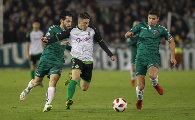 Enzo Lombardo, que este ocupó la posición de mediapunta, conduce la pelota entre dos rivales. 