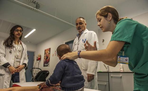 Isabel Simal, junto a Ernesto de Diego, examina el cuello de Montaca, en la consulta de Cirugía Pediátrica de Valdecilla.