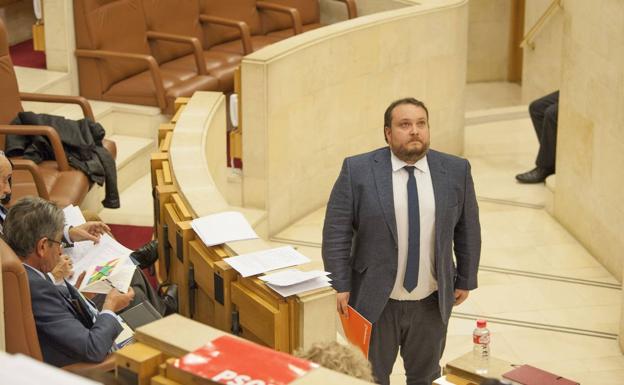 Rubén Gomez pasa por delante de Revilla en una sesión del Parlamento de Cantabria.