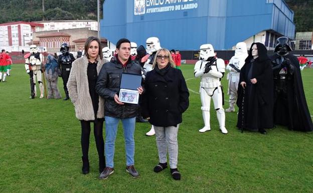 Ana María Álvarez (izquierda), madre de Rubén y Cristina Baranda, madre de Mario Vía, único superviviente del accidente, entregan al colegiado Alonso Simón, árbitro del partido, una placa. 