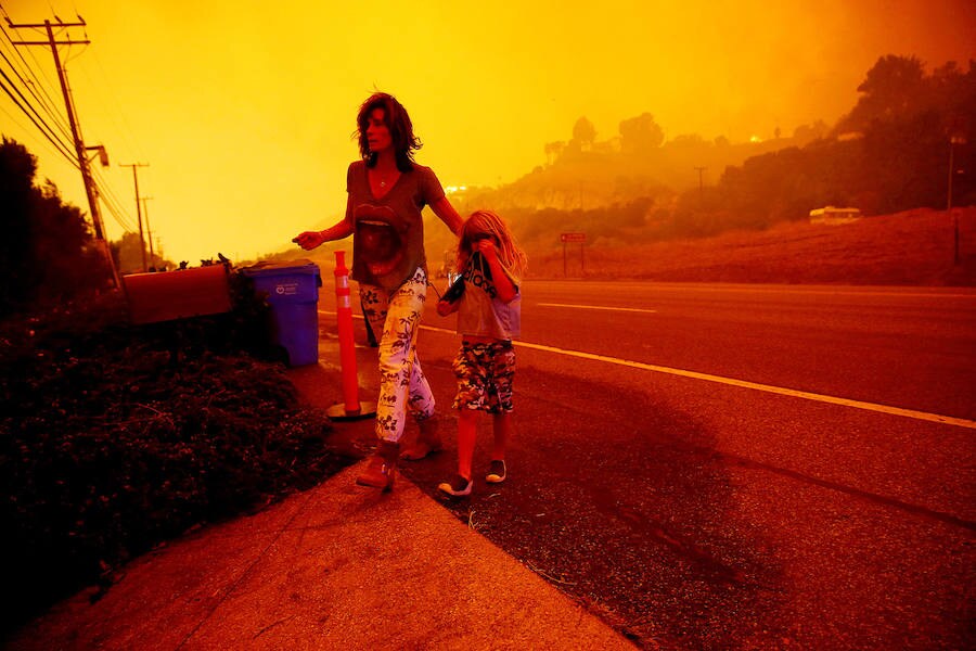 Dos personas cruzan una autopista ante la amenaza de los grandes incendios en Malibu (Estados Unidos). 