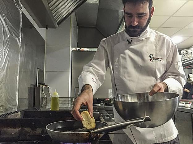 Iván Rodríguez preparando unas torrijas en la cocina de su establecimiento.