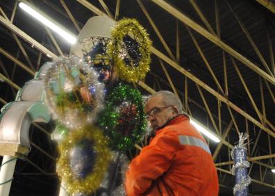 Imagen secundaria 1 - Arriba, miembros de la peña Cancerberos, que participa junto a los Ramidrejus con su obra 'Cuerdos como títeres'. Abajo, últimando los detalles de las carrozas que desfilarán. 