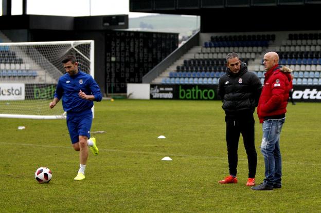 Pablo Lago charla con Carlos Bolado 'Chalana' mientras Nacho Rodríguez conduce el balón en un entrenamiento.