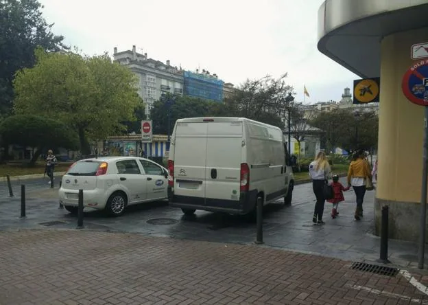 Dos coches sobre las aceras de la Plaza de Pombo, en la confluencia con Pancho Cossío. No hay bolardos y los vehículos entran. 