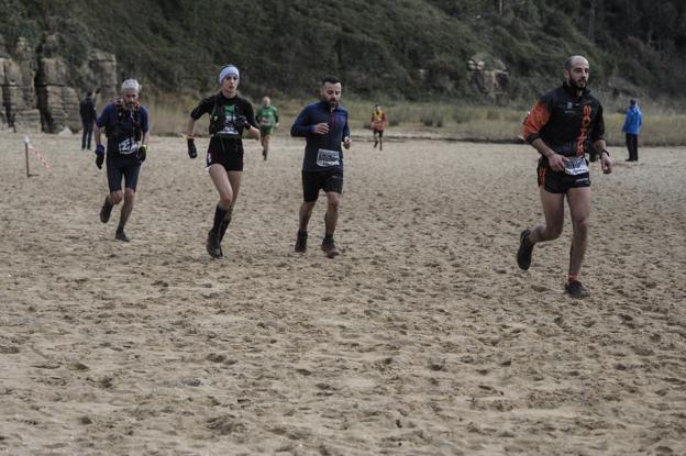 Varios participantes corren por la playa de Galizano ayer durante el Trail Costa Ribamontán al Mar.