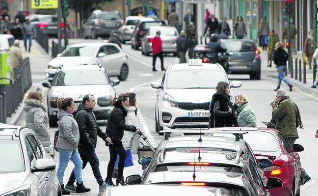 Un grupo de ciudadanos cruza un paso de peatones en la calle José María Pereda, en el centro de Torrelavega. 