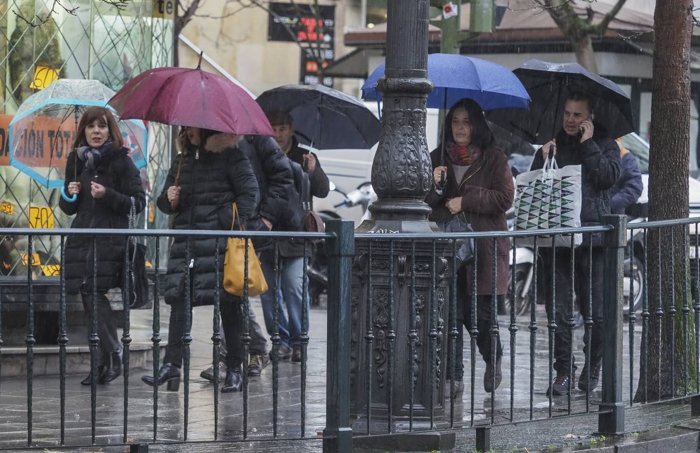 Viandantes en Santander este martes por la mañana, una desapacible jornada marcada por las lluvias y las nevadas en el interior de Cantabria
