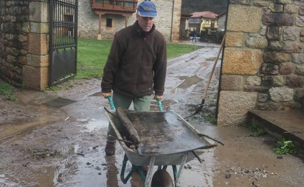 Imagen. Trabajos de limpieza de las calles y las casas de Santa Olalla, y también del río Besaya, de donde se retiran los troncos y ramas que provocaron las inundaciones en el pueblo. 