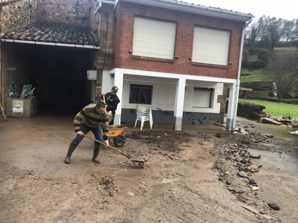 Vecinos de Santa Olalla limpian el barro que quedó en sus casas tras las inundaciones de ayer.