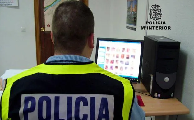 Un policía nacional revista archivos incautados a una red de pedófilos.