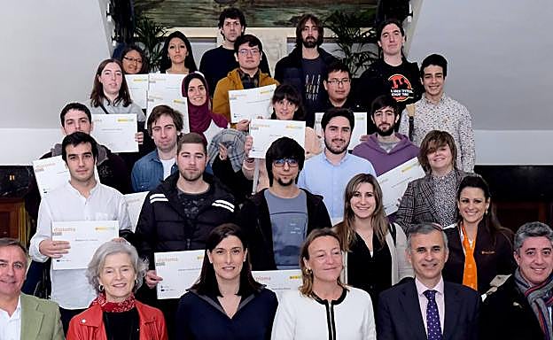 Los representantes institucionales y los alumnos con sus diplomas posan para una foto de familia.