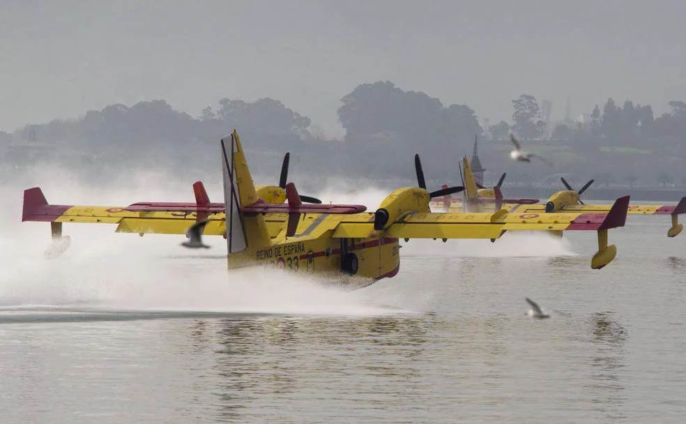 Los dos hidroaviones de la UME recogen agua en la bahía de Santander antes de desplazarse a un incendio. 