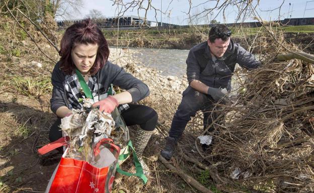 Dos voluntarios que el pasado fin de semana recogieron la basura que se ha acumulado en los márgenes del río Besaya, en la limpieza que se realizó.