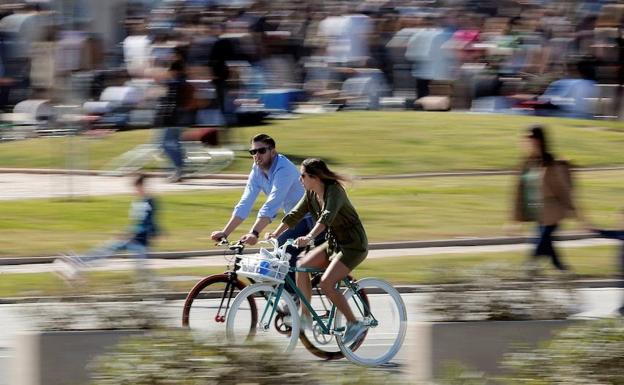 Una pareja pasea en bicicleta por Valencia.