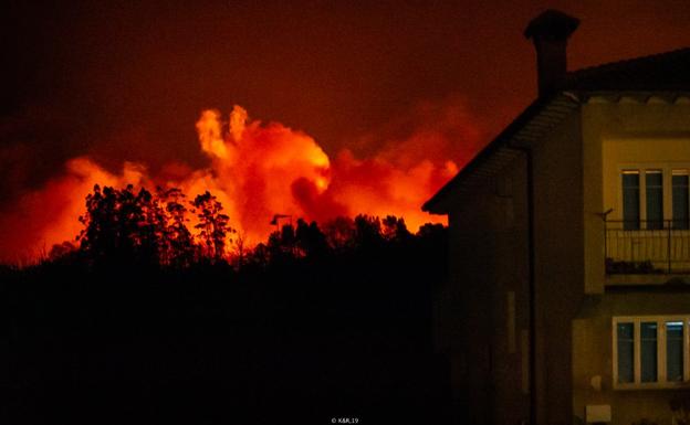 Dos miembros de la brigada de refuerzo de Ruente trabajan en la extinción de las llamas del fuego de ayer en Guzparras (Vega de Pas).