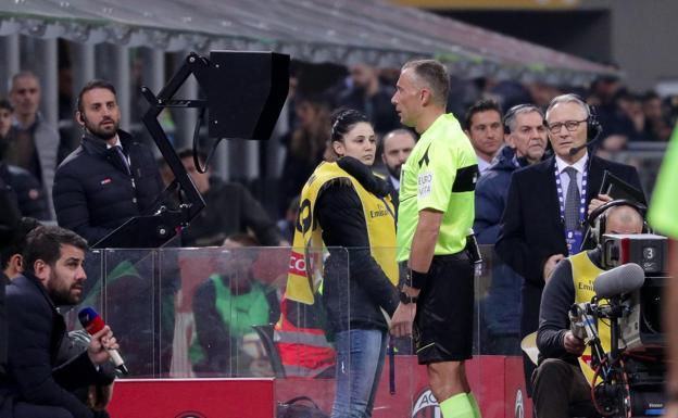Paolo Valeri mira al monitor del VAR durante el partido entre Milan y US Sassuolo