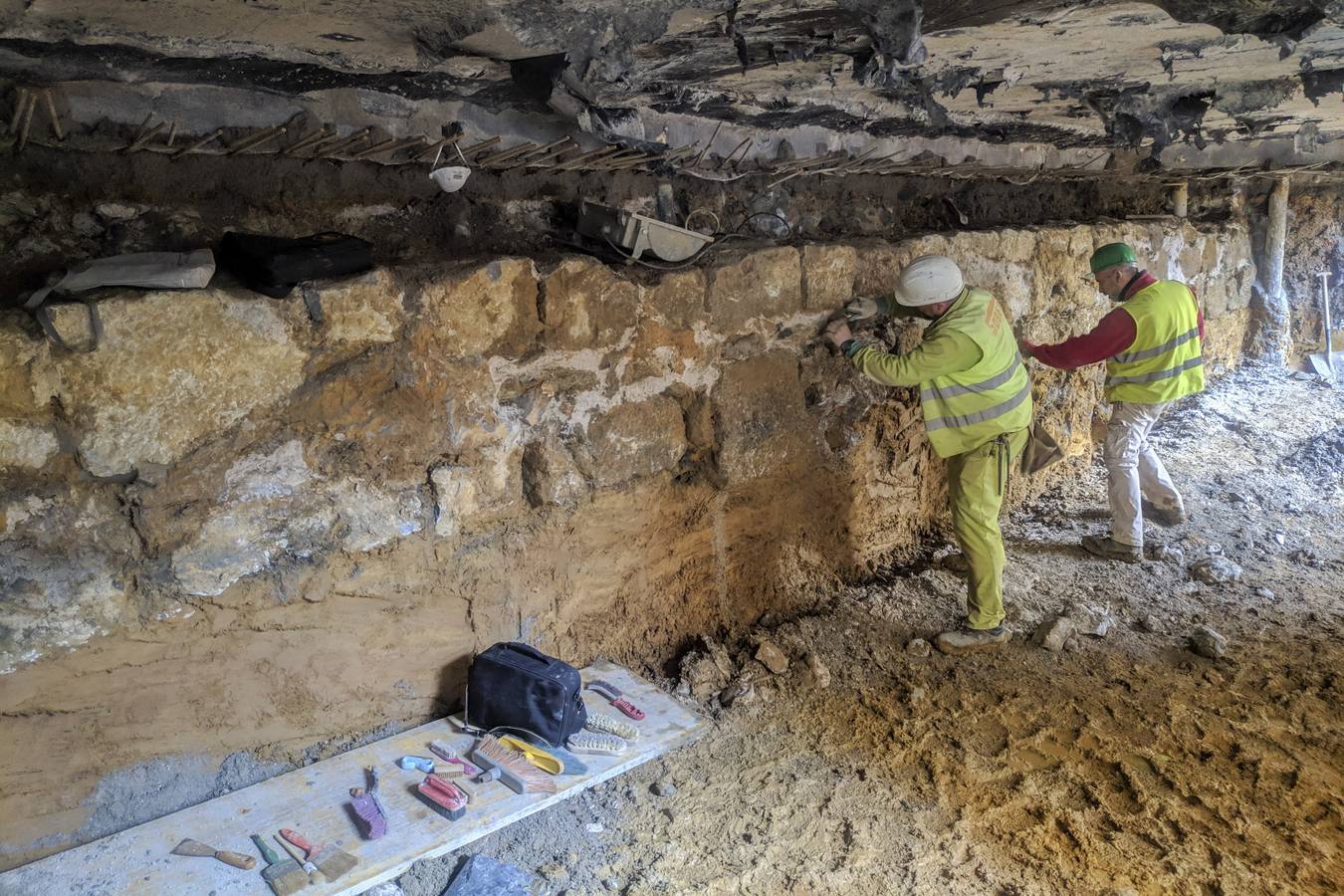 Unos operarios trabajan en el muro que ha aparecido en las obras del solar de la calle Paz. 