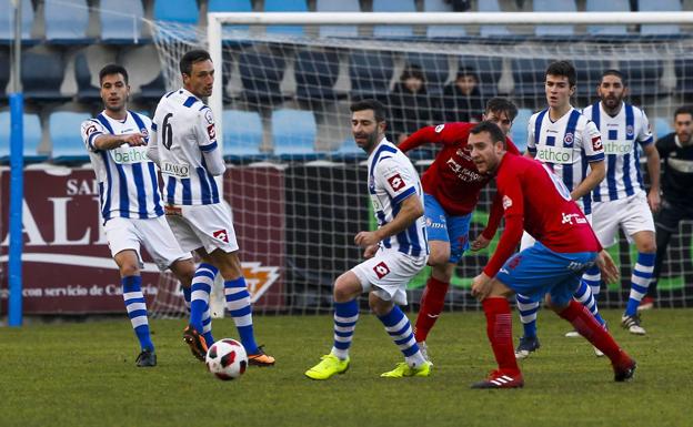 Nacho Rodríguez (centro) intenta controlar el balón ante un rival del Calahorra