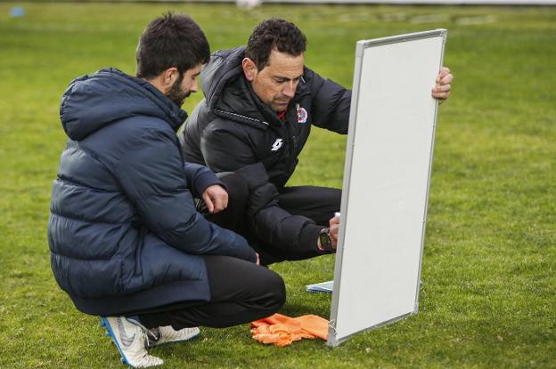 Dani Mori, junto a su segundo, Asier Canales, trabaja con la pizarra en la sesión de ayer.