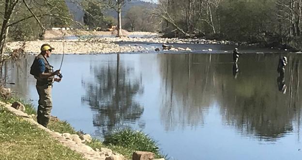 Varios pescadores en el río Saja, junto al puente de Santa LUcñia