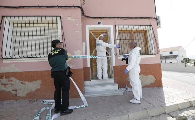 La Guardia Civil toma muestras a la puerta del domicilio donde murió tiroteado un hombre en Yéchar (Murcia).