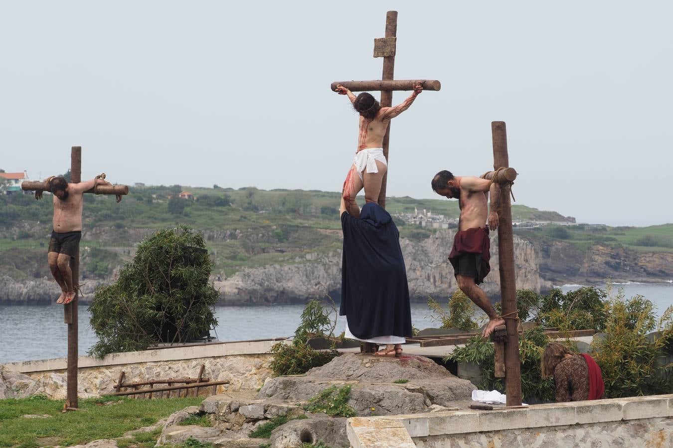 La Virgen María se acerca a besar los pies de su hijo muerto, entre los dos malechores que fueron crucificados con él. El conocido como Buen Ladrón, Dimas, fue crucificado a la derecha de Jesús y el Mal Ladrón, llamado Gestas, a su izquierda.