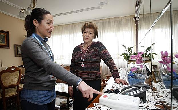 Una empleada del servicio de teleasistencia explica a una vecina de Torrelavega el funcionamiento del sistema