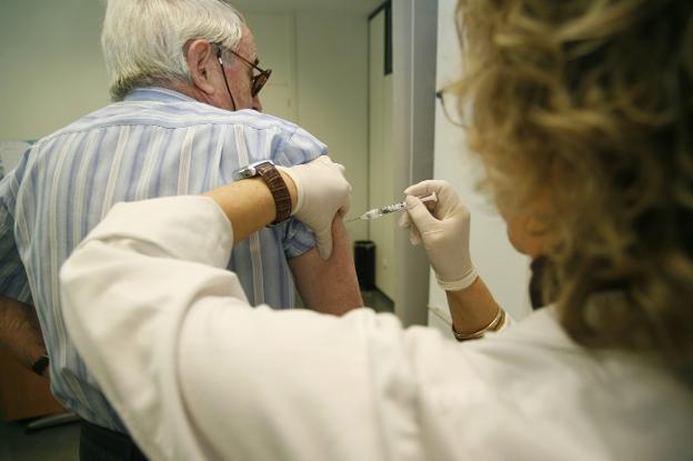 Una enfermera administra una vacuna a un paciente en un centro de salud.