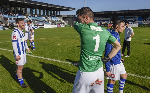 Primo, Álex Ruiz y varios compañeros suyos sobre el césped tras el partido ante el Barakaldo con la afición en pie aplaudiendo. 