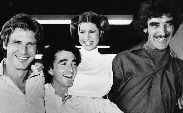 Imagen principal - Peter Mayhew con el reparto de 'La guerra de las galaxias', caracterizado como Chewbacca y junto a Harrison Ford en una convención.