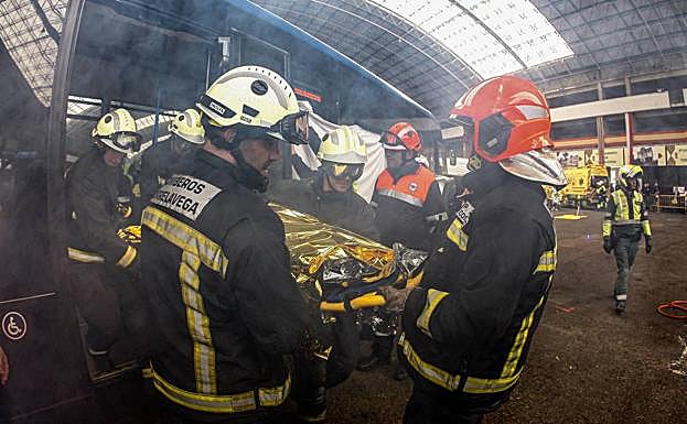 Los bomberos evacúan a uno de los heridos durante el simulacro.