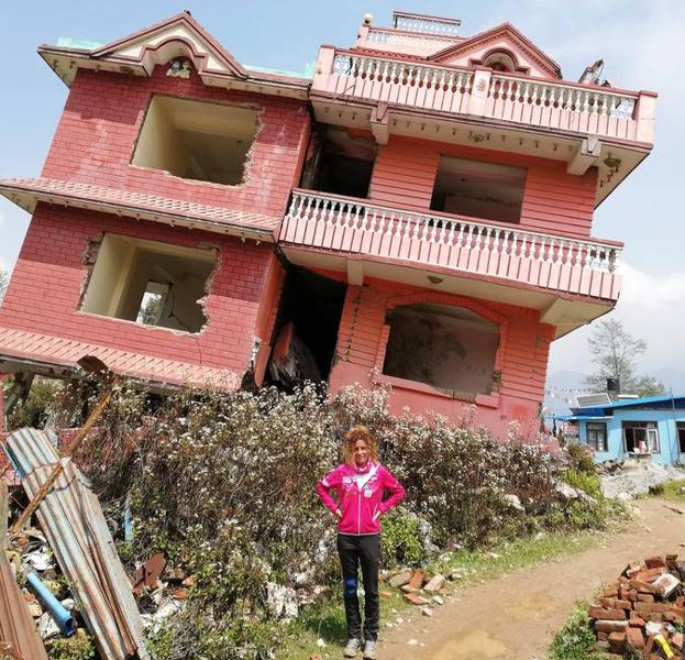 Raquel García frente a un edificio medio derruido por el terremoto que asoló parte del país en 2015.