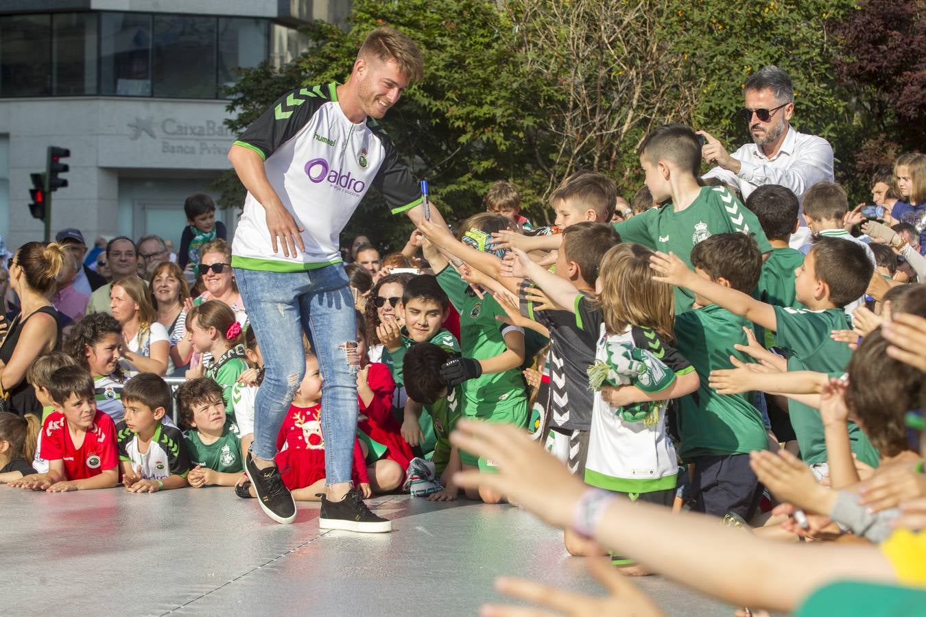 Cayarga va dando la mano a los niños reunidos en la plaza